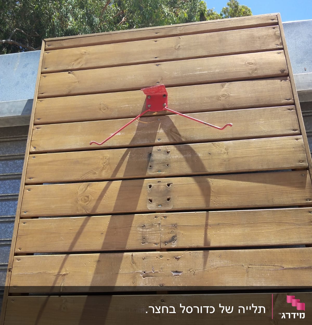 מתקן מתכת אדום על קיר עץ חום